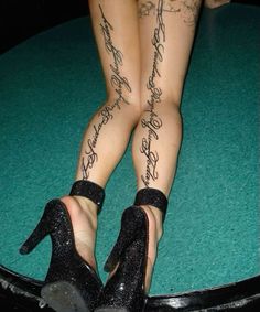 the legs and ankles of a woman wearing high heels with writing on them are shown