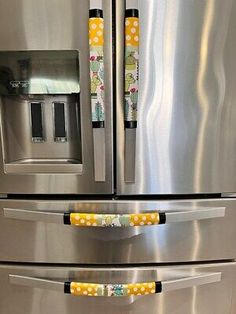 two yellow and white polka dots on the handles of a stainless steel refridgerator