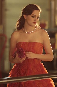 a woman in an orange dress is looking down