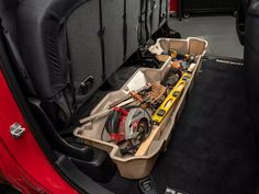 the inside of a car with tools in it's trunk and other items on the floor