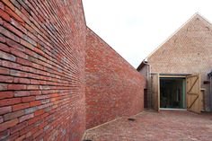 a brick building with an open door on the side and another brick building in the back