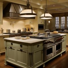 a large kitchen with an island in the middle and two pendant lights hanging from the ceiling