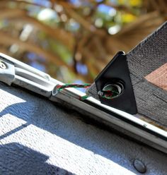 an electronic device is attached to the side of a vehicle's door handle with a green cord