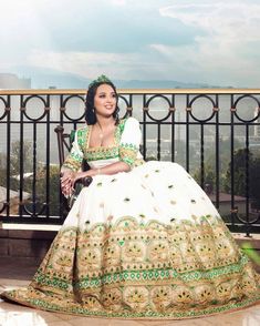 Embark on your journey of love with our "Enchanting Elegance" Habesha Wedding Dress, a masterpiece that captures the essence of romance and cultural richness. This extraordinary habesha kemis is adorned with intricate beadwork and features mesmerizing green and multicolor designs, creating a stunning and unique ensemble for your special day. Handwoven with meticulous precision and adorned with delicate embroidery, this wedding dress is crafted from Menen fabric, a lightweight cotton renowned for Traditional Wedding Gown With Traditional Patterns, Traditional Wedding Dress For Ceremonies, Wedding Gown With Traditional Patterns And Drape, Traditional Pattern Floor-length Wedding Gown, Traditional Patterned Floor-length Wedding Gown, Floor-length Wedding Gown With Traditional Patterns, Traditional White Wedding Dress For Festive Season, Traditional Floor-length Wedding Dress, Traditional White Wedding Dress With Drape