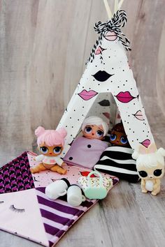 two dolls are sitting in front of a teepee tent