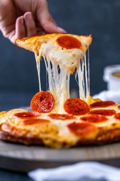 a slice of pepperoni pizza being lifted with a spatula