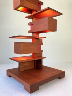 a sculpture made out of wooden blocks with lights on it's top and bottom