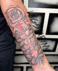 a person with a cross and flowers on their arm