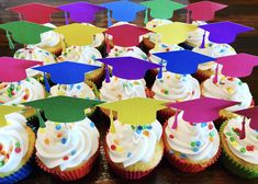 cupcakes with graduation caps and confetti on them are arranged in rows