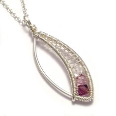 a silver necklace with pink stones hanging from it's side on a white background