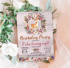 a birthday party card with flowers and butterflies on it next to a bouquet of white roses