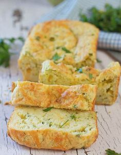 two slices of bread with herbs on top sitting on a cutting board next to parsley