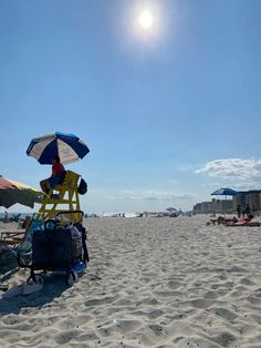 a lifeguard chair sitting on the beach under an umbrella