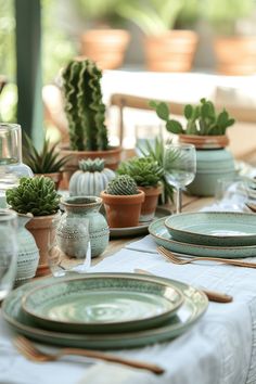 the table is set with green dishes and succulents