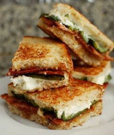 three grilled sandwiches stacked on top of each other in front of a granite counter