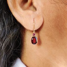 These stunning earrings are set in 14k Solid Yellow Gold with Rhodolite Garnet with utmost precision. It is an unique gemstone earring pair for nearly every occasion and is completely hassle-free jewelry. ITEM DETAILS: * Gem: Rhodolite Garnet * Gem Size: 7X9mm * Gem Shape : Oval * Gem Size: 3mm * Gem Shape : Round * Gem Weight:3.79 carats * Gold Purity: 14KT  * Gold Weight: 0.55 gram * Total Weight of the Earrings: 1.31 gram The Gold purity is guaranteed and it comes with authentic 14KT gold hallmark. Since my items are handmade, they are absolutely nickel and lead free. CUSTOMIZATION: * Gemstone customization is available and the it can be substituted with a gem of your choice. Kindly message me for the same. PACKAGING * The Earrings comes with layers of safe and secure wrapping along wit 14k Gold Drop Earrings With Gemstone Accents, Elegant Garnet Briolette Earrings, Elegant Briolette Garnet Earrings, Garnet Gemstone Earrings Fine Jewelry, Rhodolite Garnet Jewelry, Handmade Jewelry Box, Yellow Gold Earrings, Jewelry Dainty, Garnet Jewelry