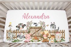 there is a baby crib with animals on it and the name alexandria written in pink