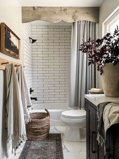 a bathroom with a toilet, sink and bathtub next to a rug on the floor