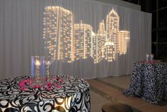 a table with a black and white cloth on it next to a large projection screen