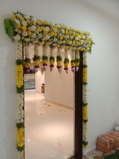 an archway decorated with flowers and greenery in the middle of a room filled with boxes