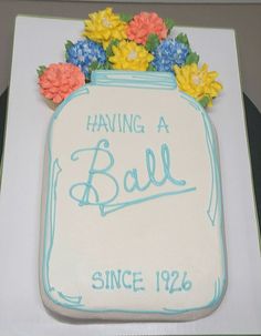 a cake with flowers on it that says having a ball since 1932 in blue and white