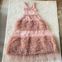 a pink dress sitting on top of a white rug