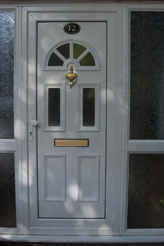 a white front door with two sidelights and a glass paneled window above it