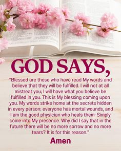 an open book sitting on top of a table next to pink flowers and the words god says