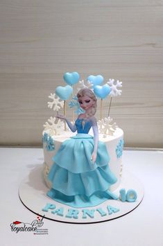 a frozen princess cake with blue frosting and balloons