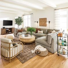 a living room filled with furniture and a flat screen tv on top of a wooden floor