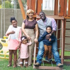 a family posing for a photo in front of a swing set