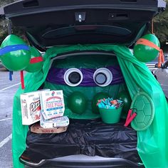 the trunk of a car decorated to look like a turtle with balloons and decorations on it