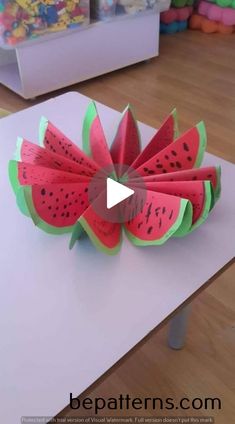 a watermelon flower made out of paper sitting on top of a white table