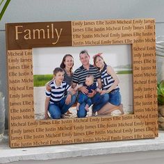 a family picture frame sitting on top of a shelf next to some rocks and plants