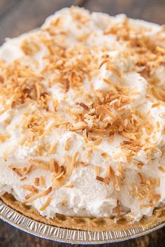 a pie with white frosting and toasted coconut on top