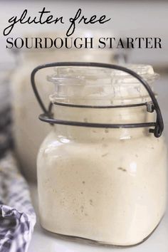 a jar filled with sourdough sitting on top of a counter next to a napkin