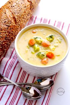 a bowl of soup next to a loaf of bread