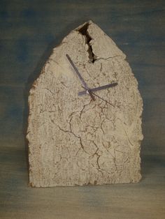 a clock made out of a rock on a table