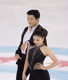 a man and woman skating on ice with one holding his arm around the other's shoulder