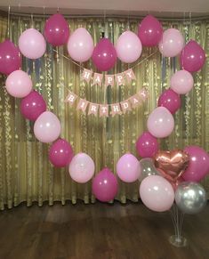 balloons and streamers in the shape of a heart are on display at a birthday party