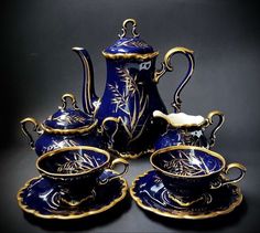 blue and gold porcelain tea set with matching saucers