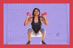 a woman squatting with two red dumbbells in front of her and an empty wall behind her