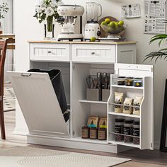 a kitchen with an open dishwasher next to a wooden table and white cabinets