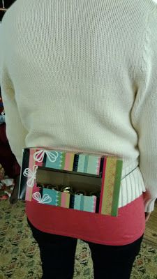 the back of a woman's white sweater holding an open gift box