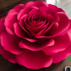 a large pink flower sitting on top of a table