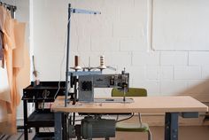 a sewing machine sitting on top of a wooden table next to a lamp and chair