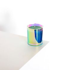 a colorful candle sitting on top of a white table