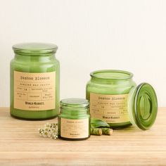 three green candles sitting on top of a wooden table