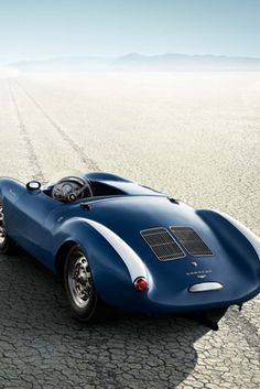 a blue sports car driving across a desert