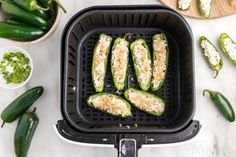 some green peppers are being cooked in a black griddle on a white counter top